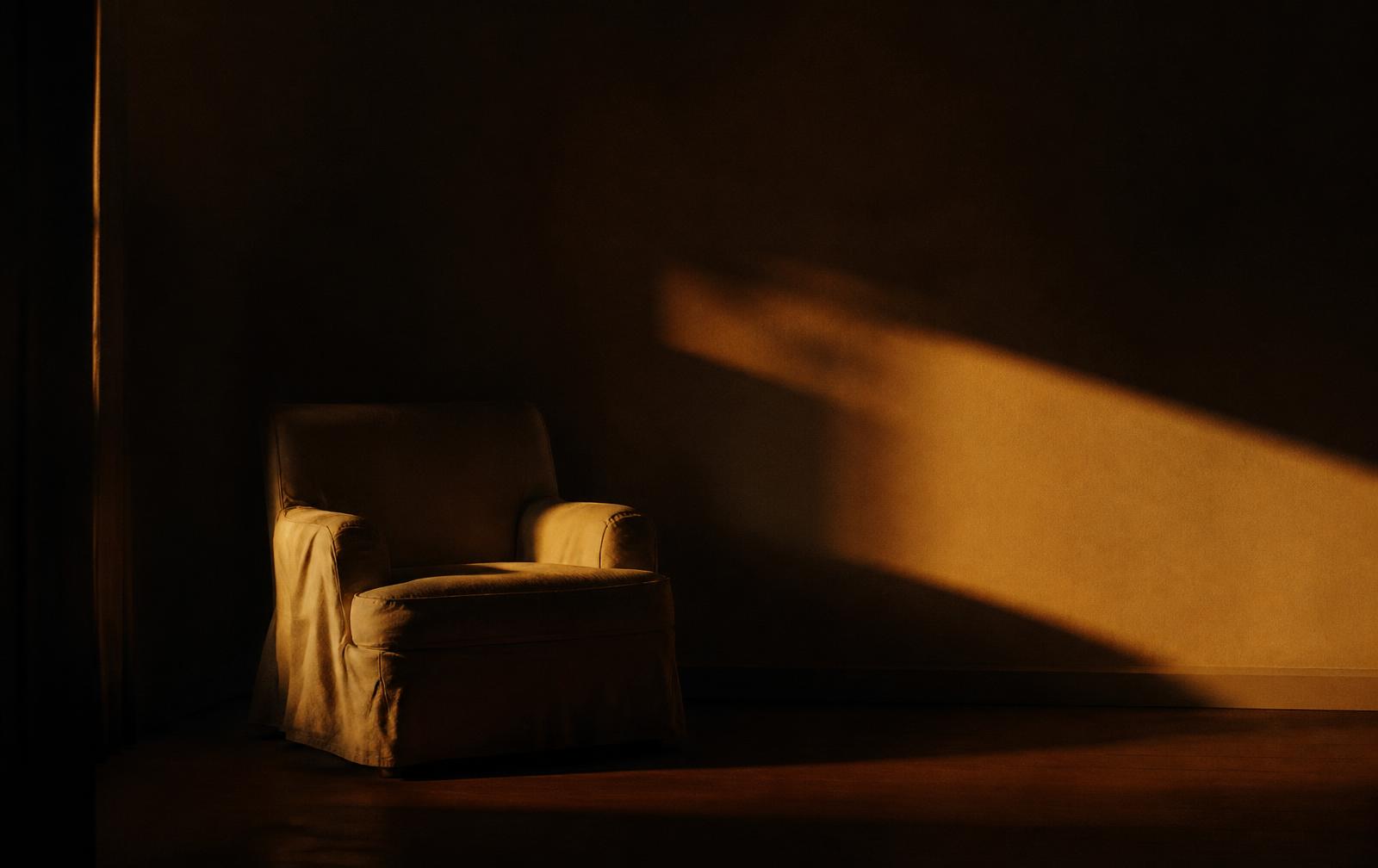 Habitación serena en penumbra con una franja de luz cálida